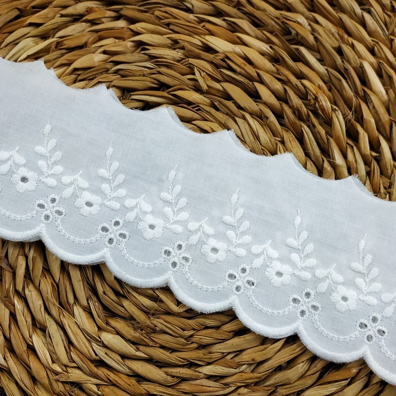 Tira bordada y perforada con flores y ondas en color blanco.